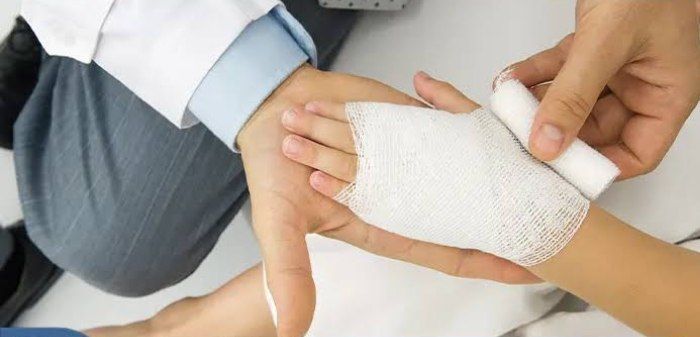 پرستار در حال پانسمان زخم بیمار در منزل با تجهیزات استریل و روش‌های استاندارد